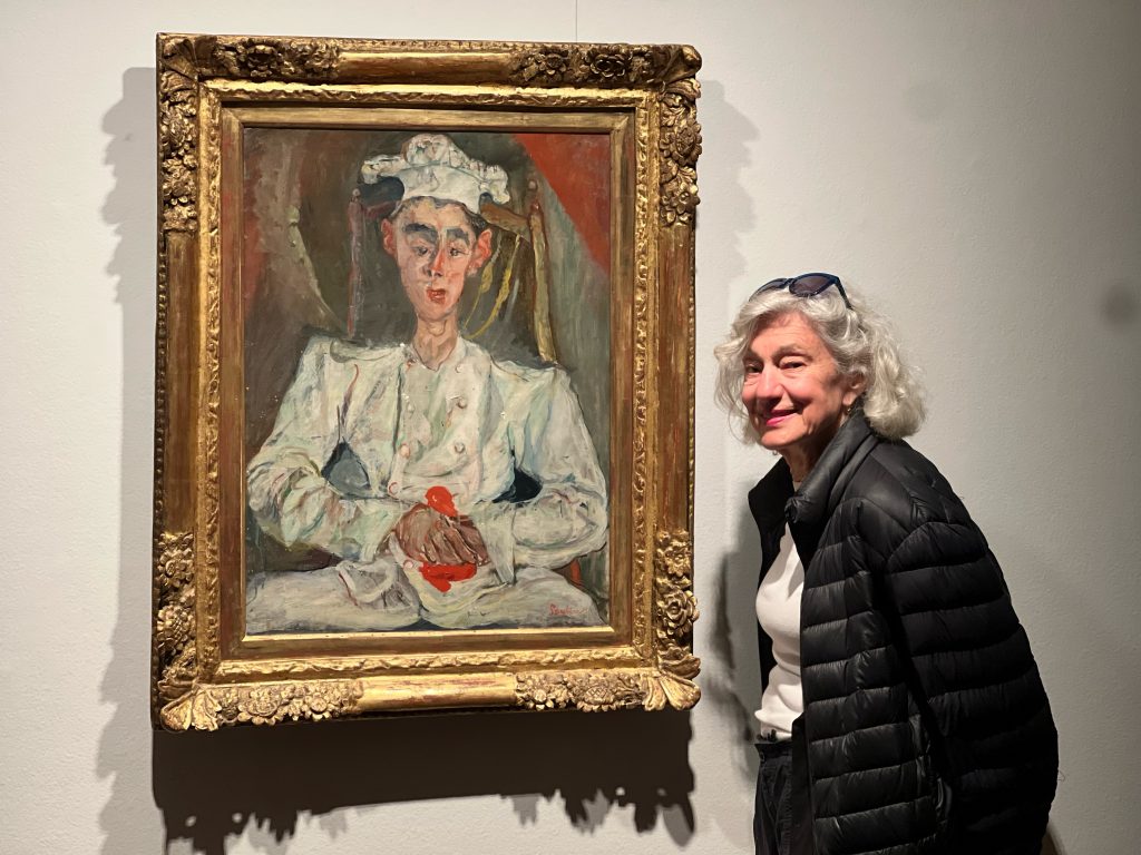 Color photo of Madge Rosenberg with painting by Chiam Soutine
